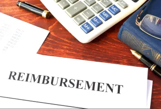 Image featuring a calculator, book, fancy pen, and a doucment titled reimbursement.