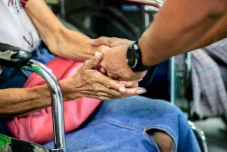 man holding hand with woman on chair by Jem Sahagun courtesy of Unsplash.