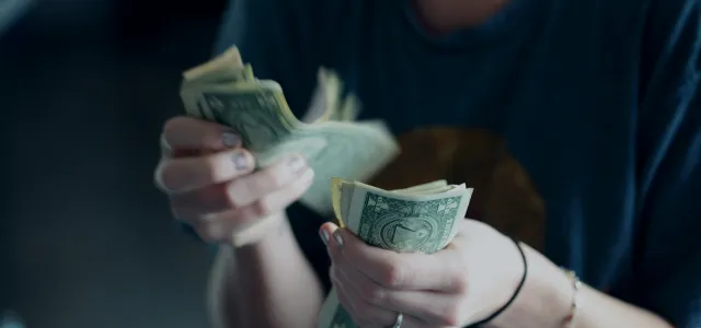 focus photography of person counting dollar banknotes by Alexander Grey courtesy of Unsplash.