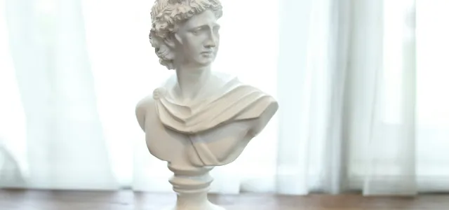 white ceramic statue on brown wooden table by Aditya Wardhana courtesy of Unsplash.